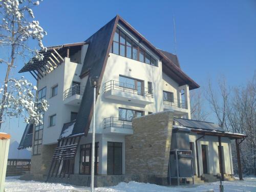 a large white building in the snow at Pensiunea Carpe Diem in Râmnicu Vâlcea