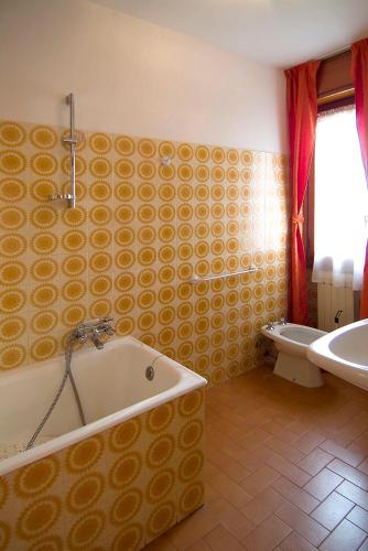 a bathroom with a tub and a toilet and a sink at Camping Hotel Au Lac De Como in Sorico