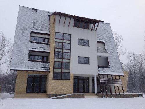 a building in the snow with snow at Pensiunea Carpe Diem in Râmnicu Vâlcea