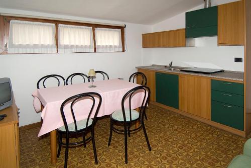 a kitchen with a pink table and four chairs at Camping Hotel Au Lac De Como in Sorico