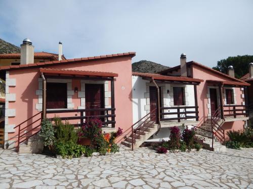 een roze huis met bloemen ervoor bij Mountain Ηouse in Arcadia in Vytina