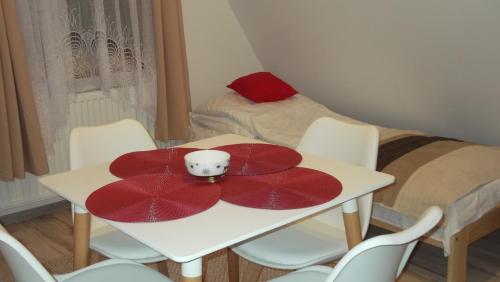 a room with a table with a red plate on it at Apartamenty Lejówka in Chochołów