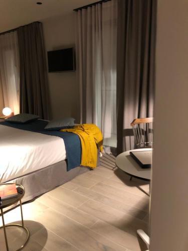a bedroom with a bed with a yellow blanket on it at HOTEL TORRENT in L'Escala