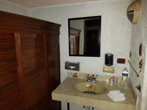 a bathroom with a sink and a mirror at State Inn in Chihuahua