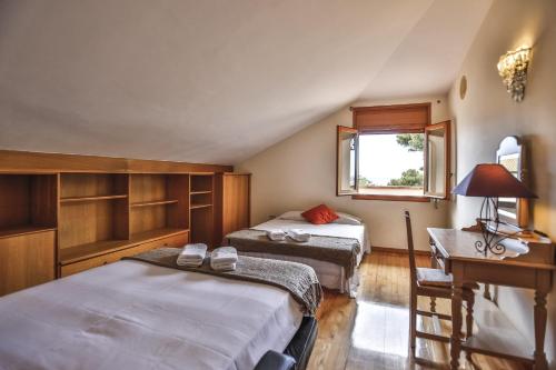ビラノバ・イ・ラ・ジャルトルにあるVilla El Faro by Hello Homes Sitgesのベッドルーム1室(ベッド2台、デスク、窓付)