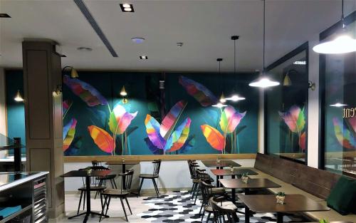 a restaurant with tables and butterflies painted on the wall at HOTEL TORRENT in L'Escala