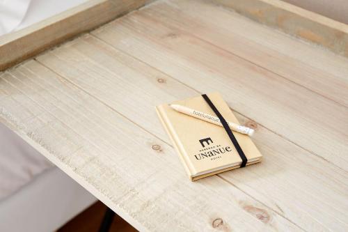 a book on a table with a pencil on it at Heredad de Unanue in Donostia-San Sebastián