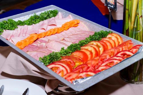 a tray of meat and vegetables on a table at Rincon del Valle Hotel & Suites in San José
