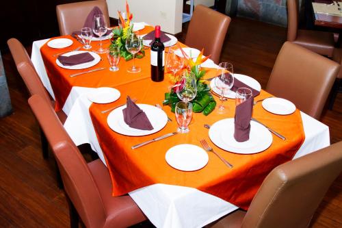 a table with a orange table cloth on it at Rincon del Valle Hotel & Suites in San José