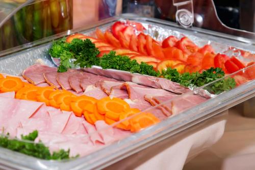 a tray of different types of meats and vegetables at Rincon del Valle Hotel & Suites in San José
