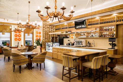 a restaurant with a bar with tables and chairs at Родичі in Zhashkiv