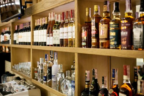 a shelf filled with lots of bottles of alcohol at Родичі in Zhashkiv