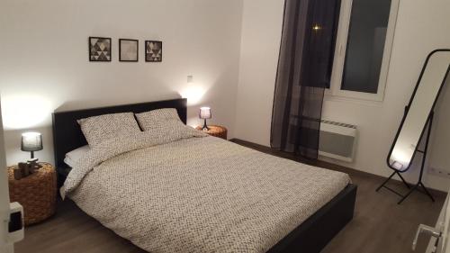 a bedroom with a large bed and a window at Appart Confortable à Tulle - Bien situé - Calme in Tulle