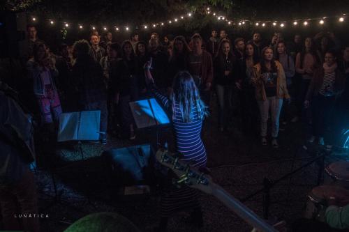 a crowd of people watching a woman in front of a stage at Destino26 Hostel in Montevideo