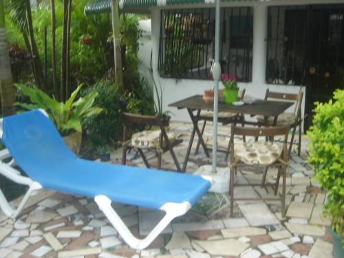 a blue chair and a table and chairs on a patio at Dre Broeders Apartments Juan Dolio in Juan Dolio