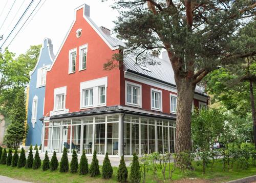 a large red and blue house with a tree at Madame L & SPA in Svetlogorsk