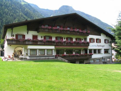 a building with flowers on the balconies of it at Hotel Reichegger in Villa Ottone