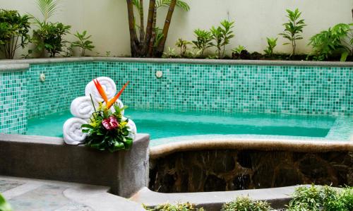 a swimming pool with a flower arrangement in front of it at Rincon del Valle Hotel & Suites in San José