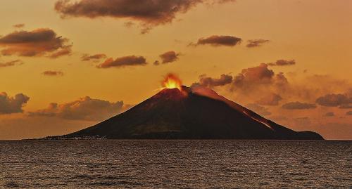 a volcano in the middle of the ocean at sunset at Hotel Ossidiana Stromboli Center in Stromboli