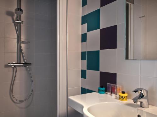 a bathroom with a sink and a shower at Hôtel des Métallos in Paris