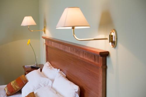 a bedroom with two lamps and a bed with pillows at Country Hotel & Resort I Calanchi in Ripatransone
