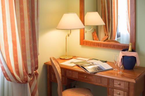 a desk in a room with a lamp and a mirror at Country Hotel & Resort I Calanchi in Ripatransone