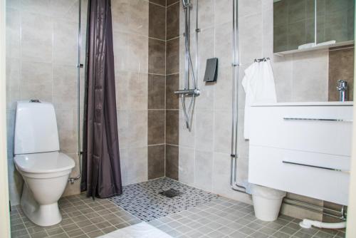 a bathroom with a toilet and a glass shower at Lindesbergs Stadshotell in Lindesberg