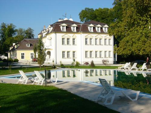 a large white house with chairs and a swimming pool at Appartement Kastelo Teraso in Zalacsány