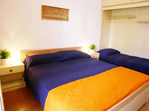 a bedroom with a blue and orange bed in a room at Condominio Alto Adriatico in Grado