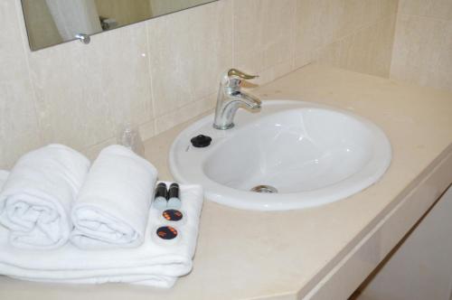 umywalka w łazience z ręcznikami na ladzie w obiekcie Urban Flamingo Residence w mieście Portimão