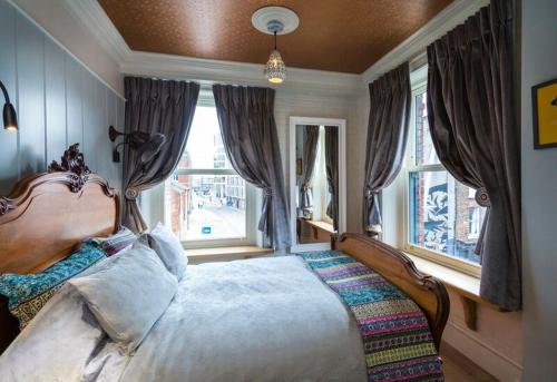 a bedroom with a large bed in front of windows at McGettigan's Townhouse - Olives & Figs Bistro in Dublin