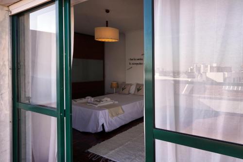 a room with a bed and a glass door at Amadora Terrace View in Amadora