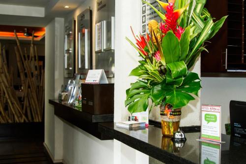a counter with a vase of flowers on it at Rincon del Valle Hotel & Suites in San José