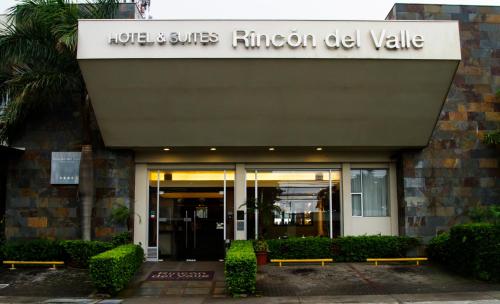 a hotel entrance with benches in front of a building at Rincon del Valle Hotel & Suites in San José