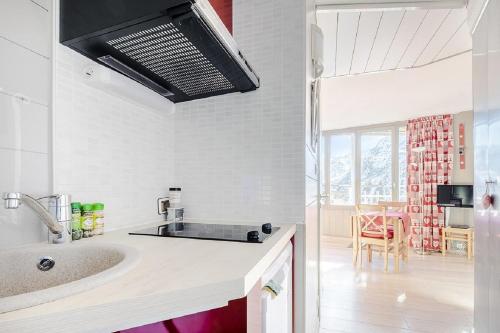 eine weiße Küche mit einem Waschbecken und einem Esszimmer in der Unterkunft Residence Les Ruches - maeva Home in Avoriaz