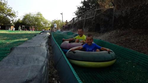 two boys are riding in inflatable tubes at a water park at B&B La Casetta in Aci Bonaccorsi