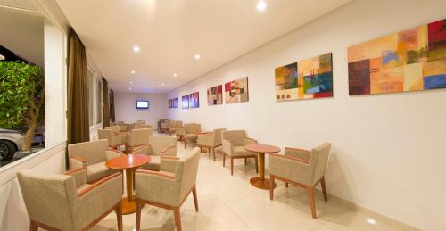 a waiting room with chairs and tables and paintings at Hotel Gran Sol in San Antonio