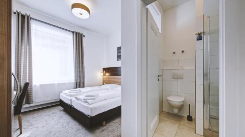 a bathroom with a bed and a toilet in a room at Boutique-Hotel Kronenstuben in Ludwigsburg