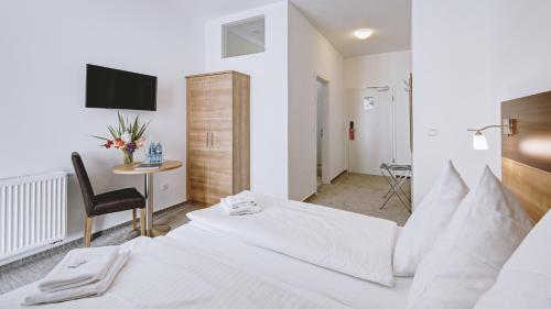 a hotel room with two beds and a desk at Boutique-Hotel Kronenstuben in Ludwigsburg