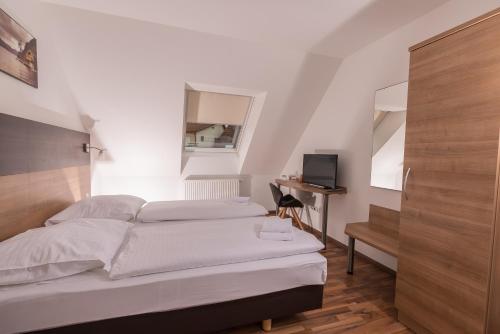 a bedroom with a white bed and a desk at Boutique-Hotel Kronenstuben in Ludwigsburg