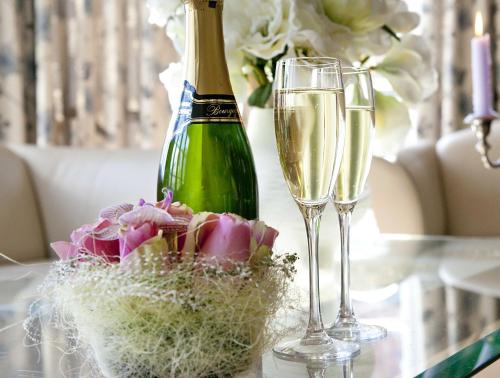 a bottle of champagne and two glasses on a table at Sølvgarden Hotel in Rysstad