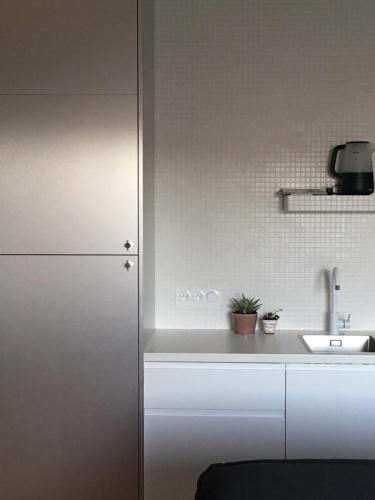 une cuisine avec un réfrigérateur blanc et un évier dans l'établissement Joie Paris Porte Maillot - Palais Des Congrès, à Neuilly-sur-Seine