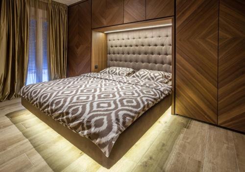 a bedroom with a large bed with a large headboard at Bella Roe Premium Apartments in Belgrade