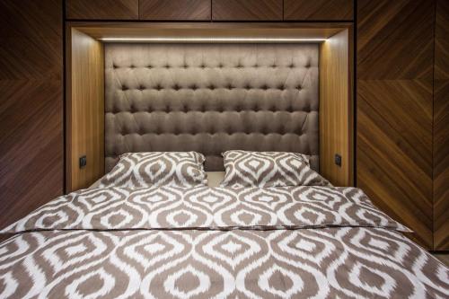 a bed with a padded headboard and two pillows at Bella Roe Premium Apartments in Belgrade