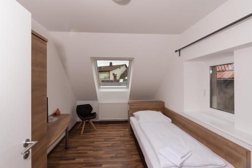 a bedroom with a bed and a desk and a window at Boutique-Hotel Kronenstuben in Ludwigsburg