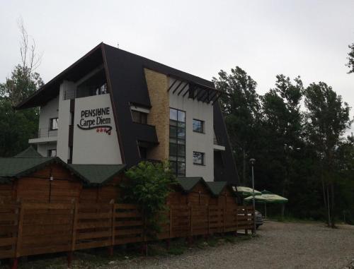 a building with a fence in front of it at Pensiunea Carpe Diem in Râmnicu Vâlcea
