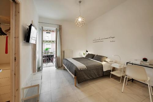 a bedroom with a bed and a table and a desk at Piazza Salvatore 7, gocce di sicilia in Ragusa