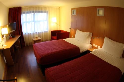 Habitación de hotel con 2 camas y escritorio en Station House Hotel Letterkenny, en Letterkenny