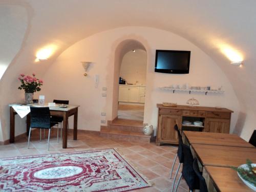 a living room with a table and a tv at Bed&Breakfast Giardini di Corte in Toscolano Maderno