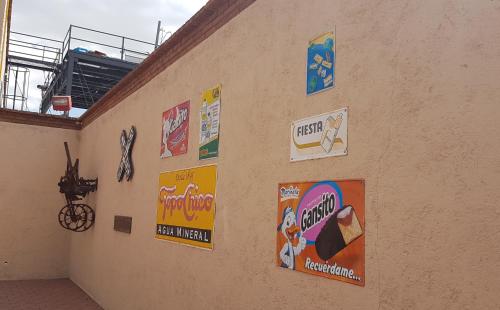 a group of signs on the side of a building at State Inn in Chihuahua